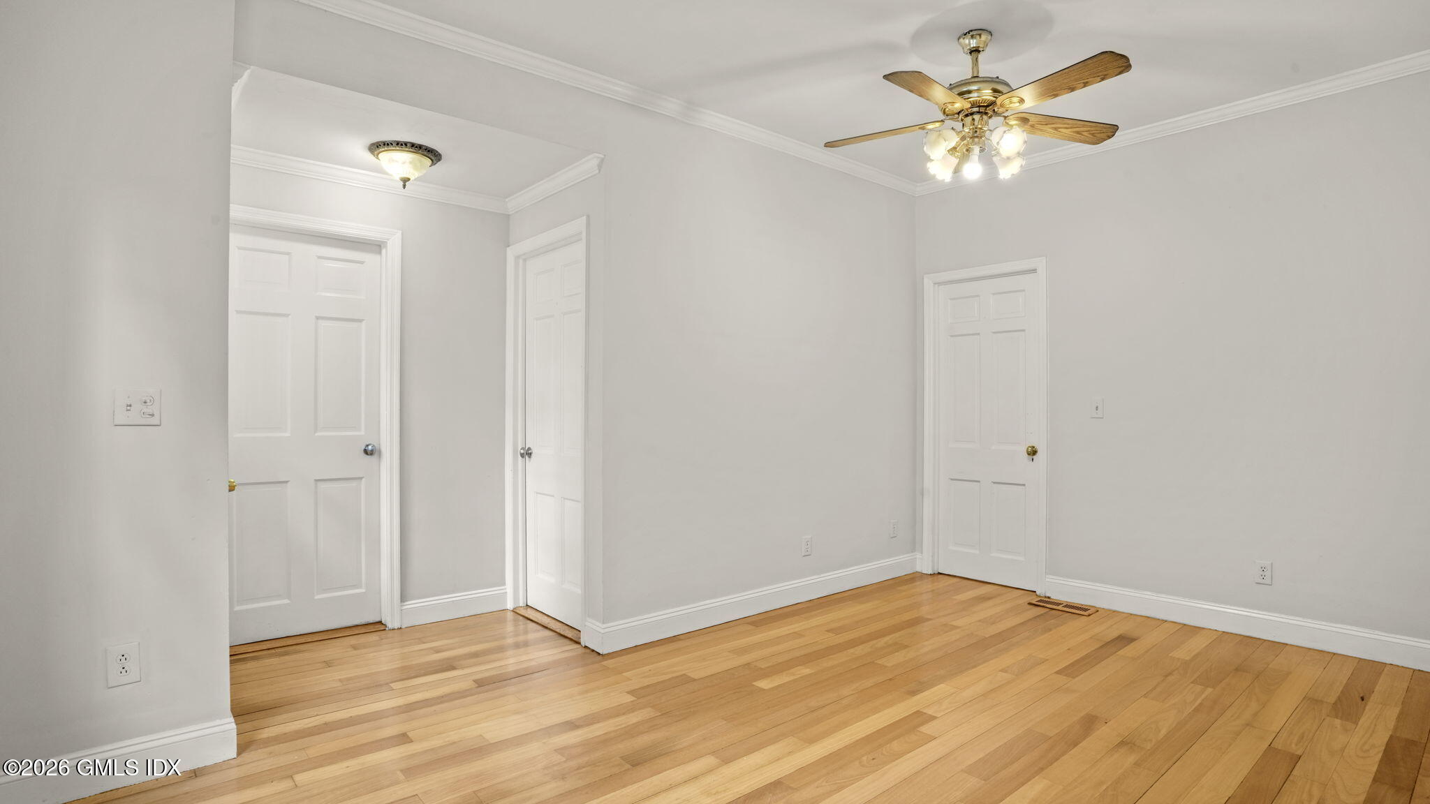 43 Church Street, Unit 1 Greenwich, CT 06830 - Photo 10 of 17 an empty room with a chandelier fan and wooden floor