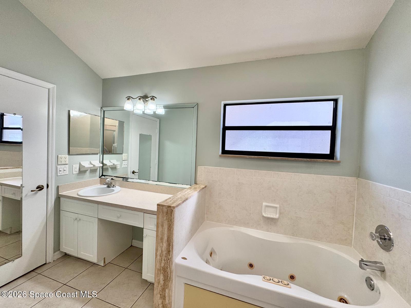 2168 Misty Way Lane Melbourne, FL 32935 - Photo 10 of 19 a bathroom with a bathtub a mirror a sink and vanity