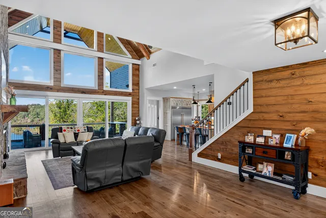 a living room with furniture a fireplace and floor to ceiling windows