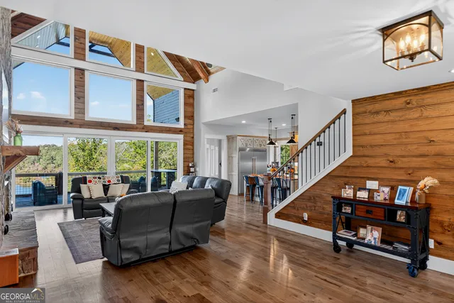 a living room with furniture a fireplace and floor to ceiling windows