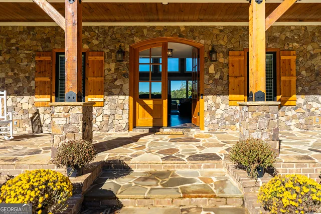 a living room with furniture a fireplace and floor to ceiling windows