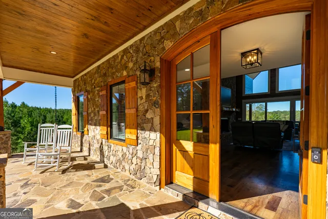 a living room with furniture a fireplace and floor to ceiling windows