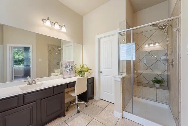 a bathroom with a double vanity sink mirror and shower