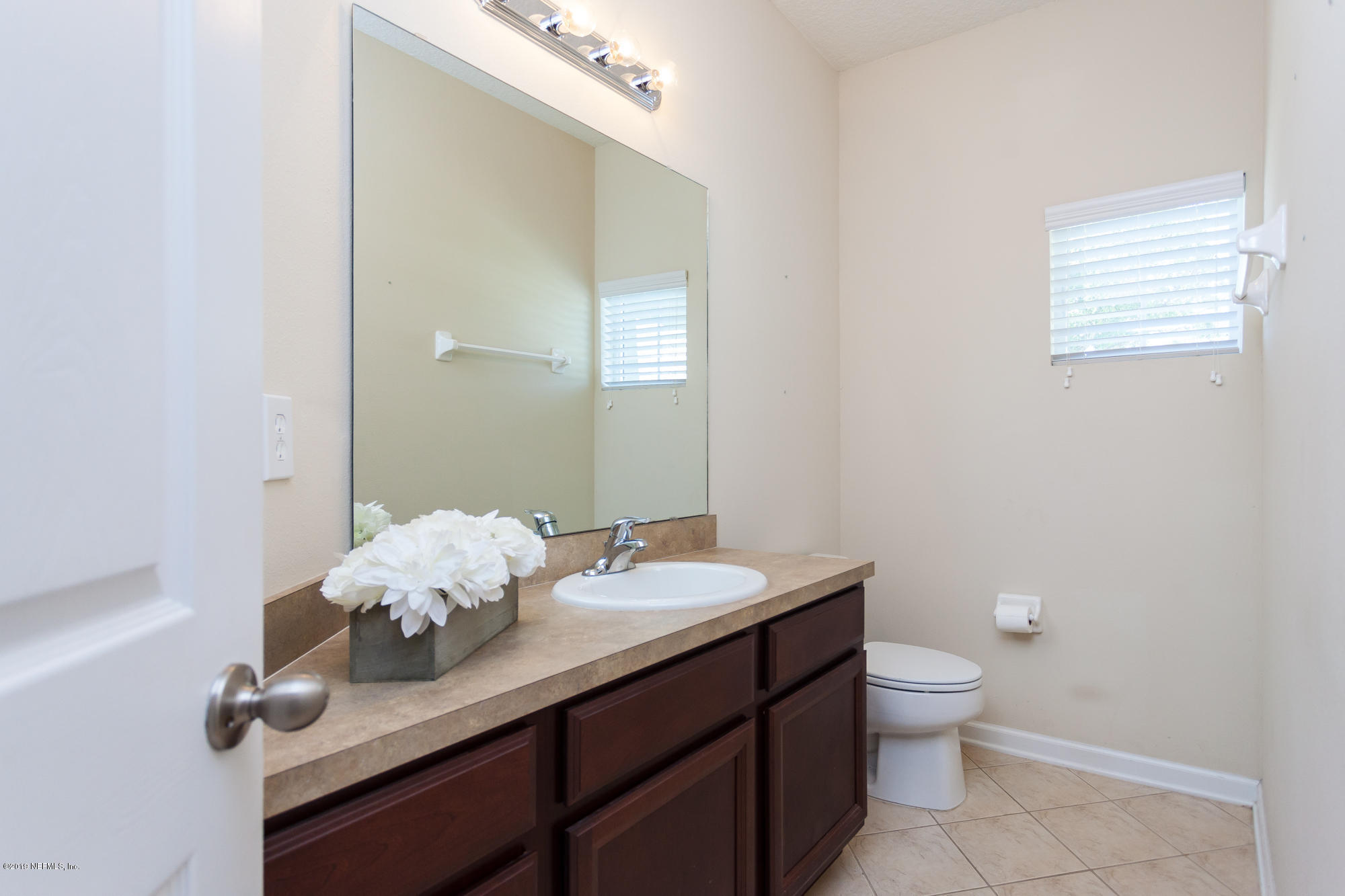 3256 Chestnut Ridge Way Orange Park, FL 32065 - Photo 26 of 39 a bathroom with a granite countertop sink a toilet and a mirror
