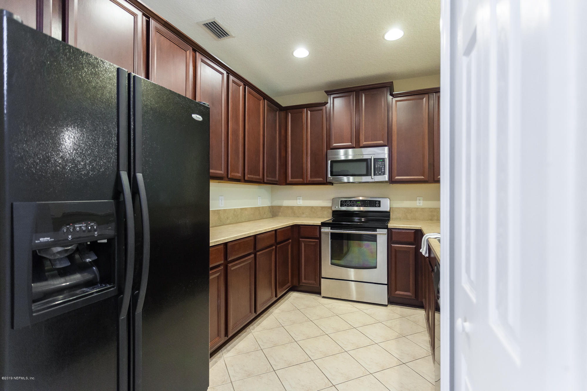 3256 Chestnut Ridge Way Orange Park, FL 32065 - Photo 5 of 39 a kitchen with granite countertop stainless steel appliances and refrigerator