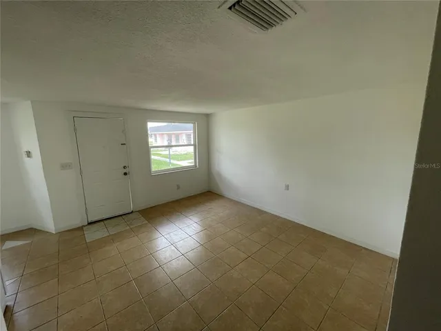 a kitchen with a refrigerator a stove top oven and white cabinets