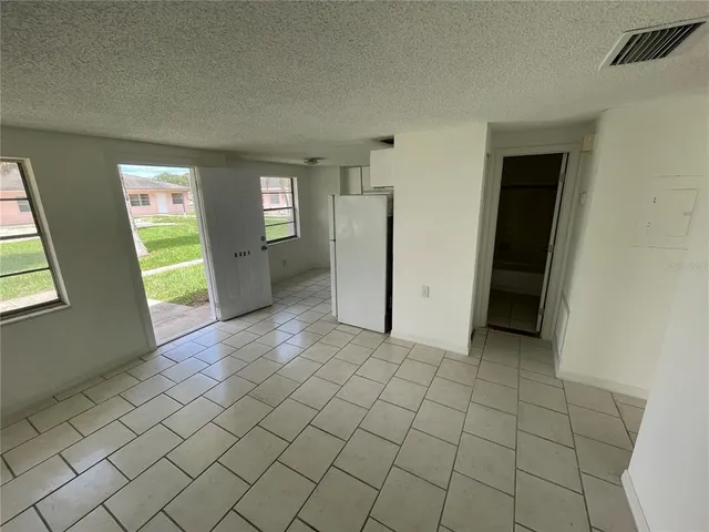 an empty room with windows and cabinet