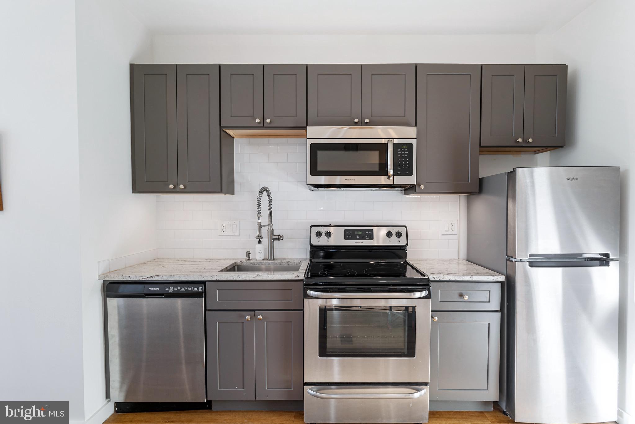 2465 18th Street Northwest, Unit 1 Washington, DC 20009 - Photo 8 of 17 a kitchen with cabinets stainless steel appliances and a counter space