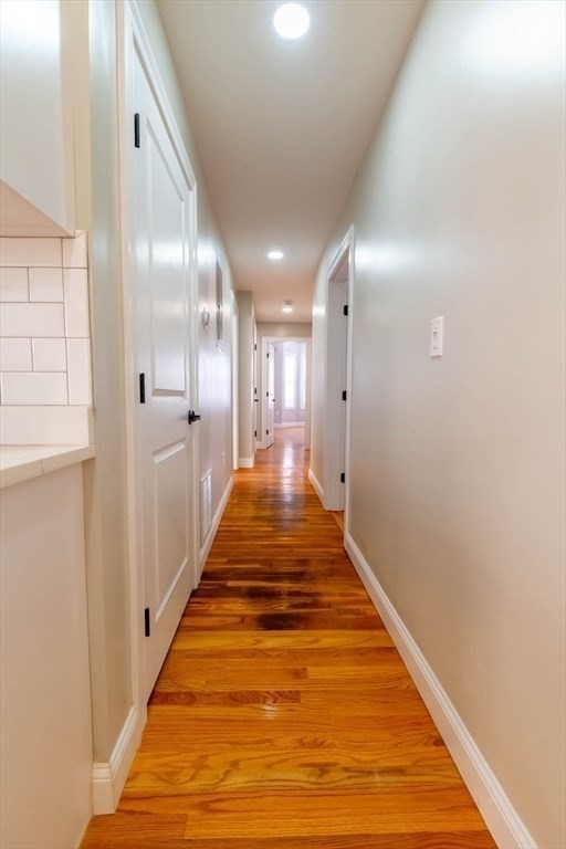 28-30 Chestnut Avenue, Unit 3 Boston, MA 02130 - Photo 11 of 17 a hallway with white walls and wooden floor