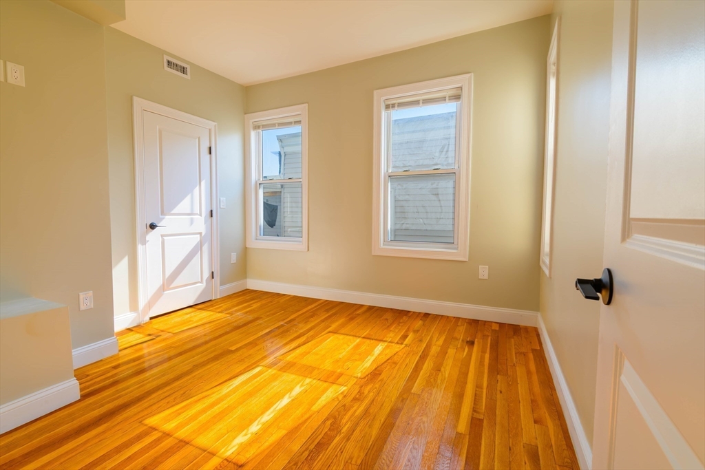 28-30 Chestnut Avenue, Unit 3 Boston, MA 02130 - Photo 6 of 17 a view of an empty room with wooden floor and a window