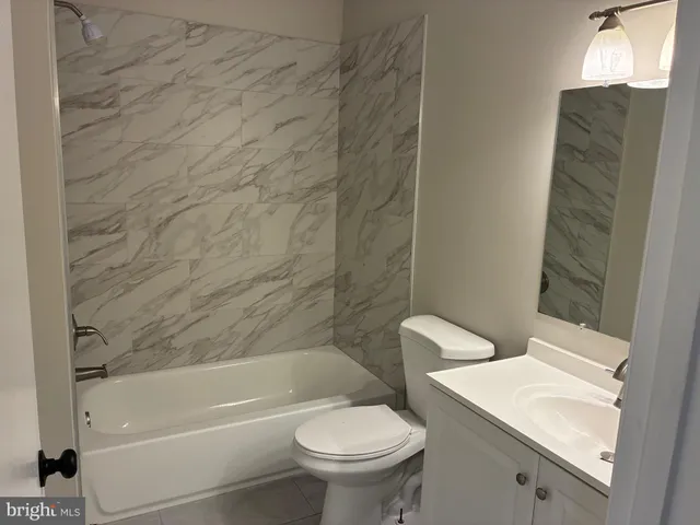 a white toilet sitting next to a bath tub