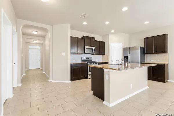 a kitchen with granite countertop stainless steel appliances cabinets a sink and a counter top space