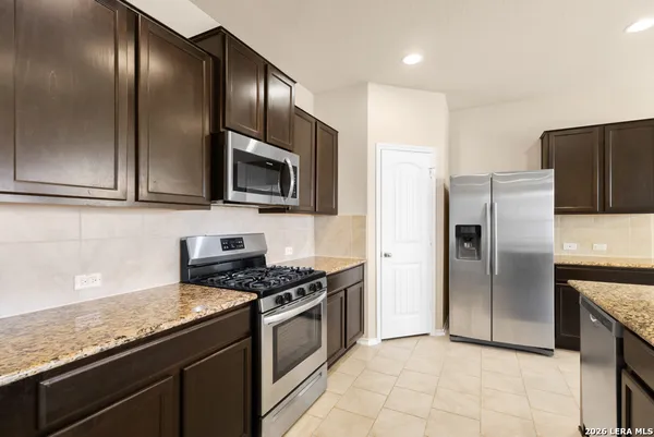 a kitchen with granite countertop stainless steel appliances cabinets a sink and a counter top space