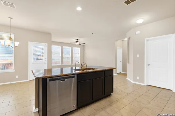 a kitchen with kitchen island granite countertop a stove sink and refrigerator