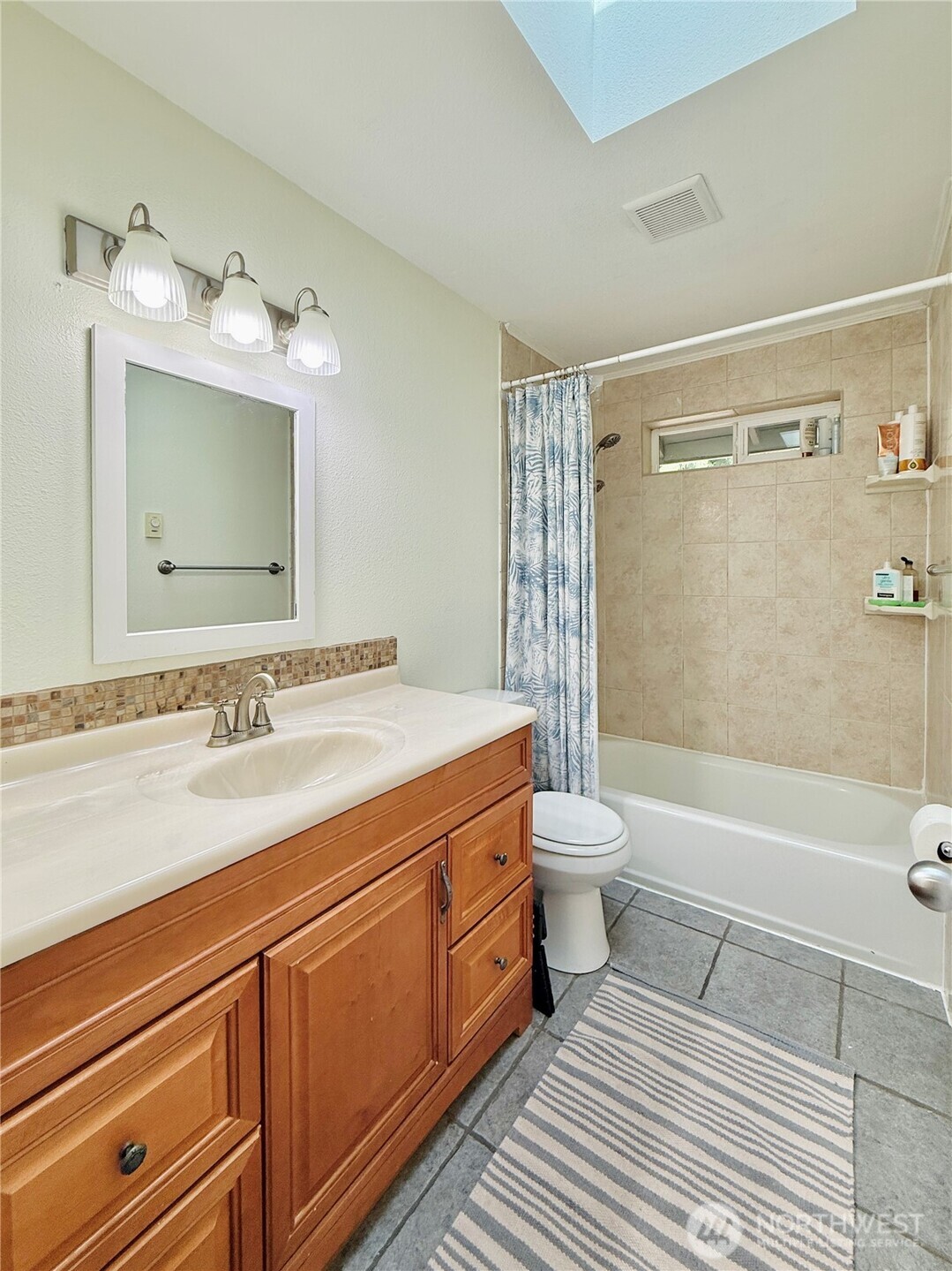 11422 Leschi Circle Anderson Island, WA 98303 - Photo 18 of 40 a bathroom with a granite countertop sink a toilet a mirror and shower