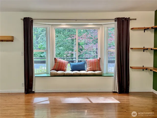 a dining room with wooden floor a chandelier a glass table and chairs