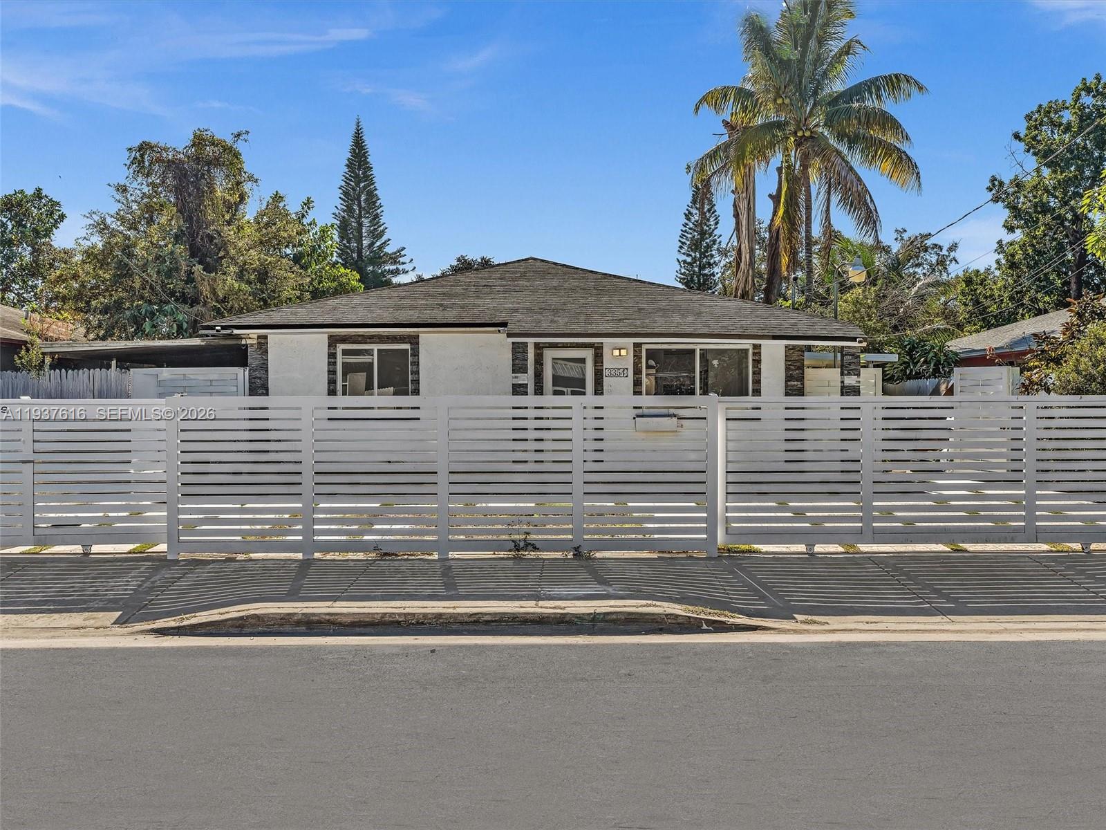 3354 Northwest 50th Street, Unit 3354 Miami, FL 33142 - Photo 1 of 26 a front view of a house with a yard and garage