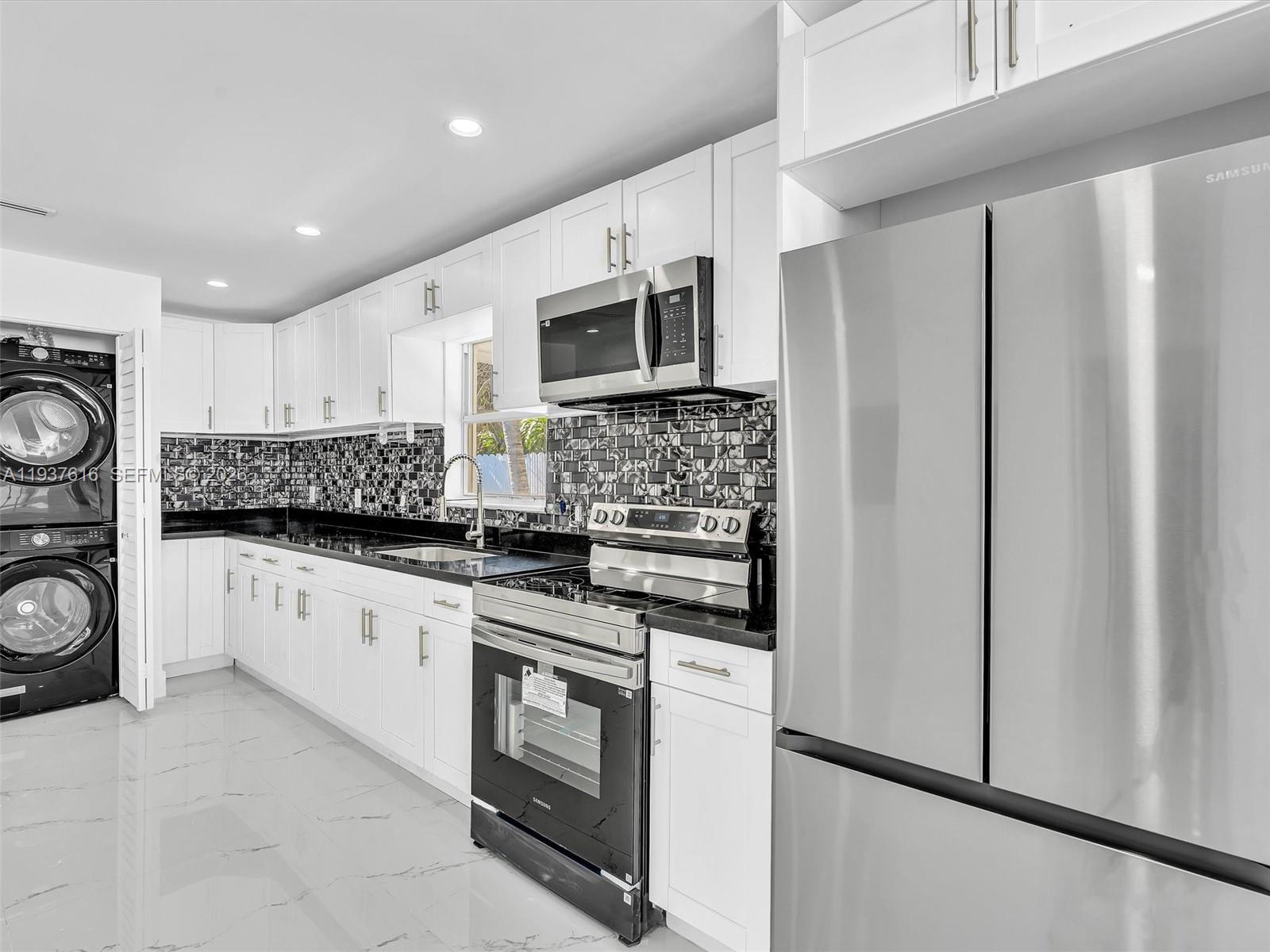 3354 Northwest 50th Street, Unit 3354 Miami, FL 33142 - Photo 12 of 26 a kitchen with stainless steel appliances a refrigerator stove microwave and sink