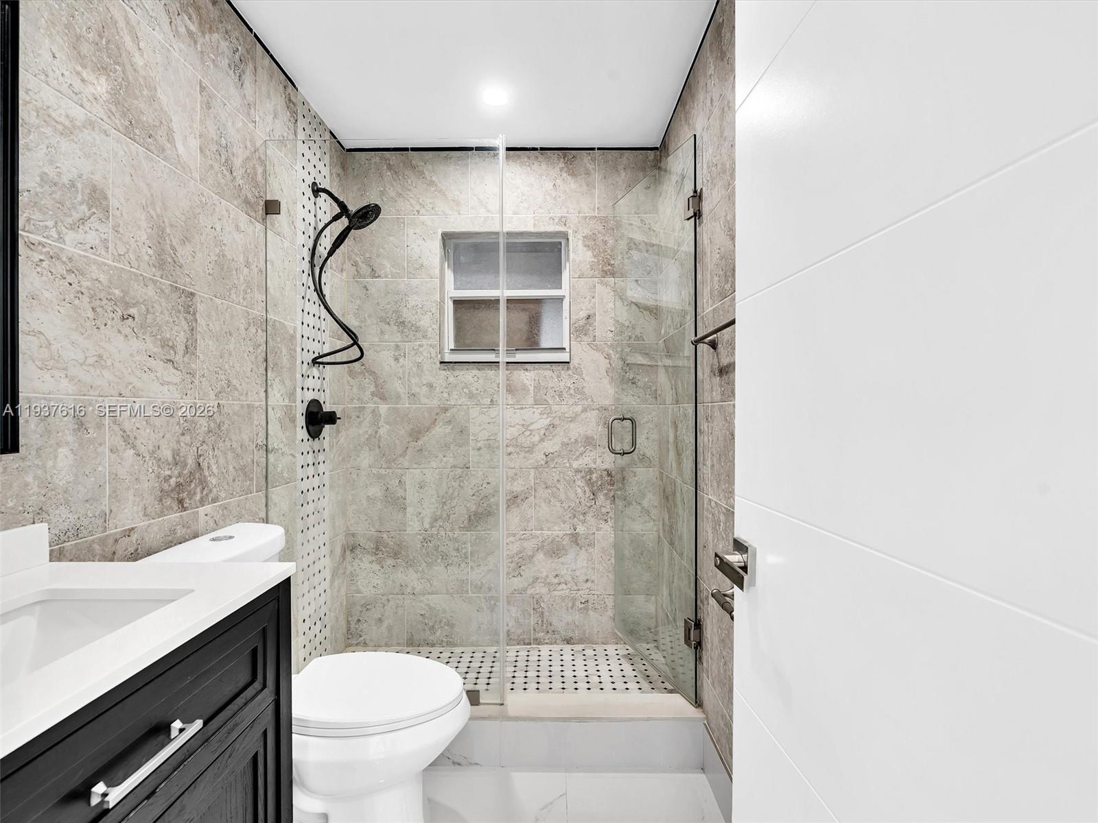 3354 Northwest 50th Street, Unit 3354 Miami, FL 33142 - Photo 19 of 26 a bathroom with a shower toilet and sink