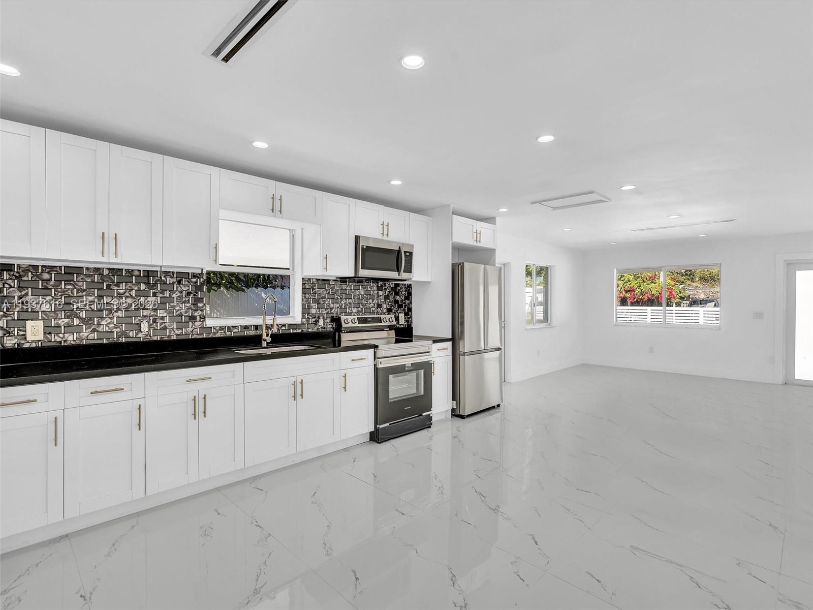 3354 Northwest 50th Street, Unit 3354 Miami, FL 33142 - Photo 6 of 26 a kitchen with granite countertop white cabinets and stainless steel appliances