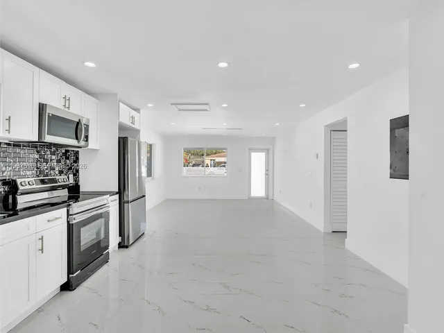 a view of a kitchen with a refrigerator and window
