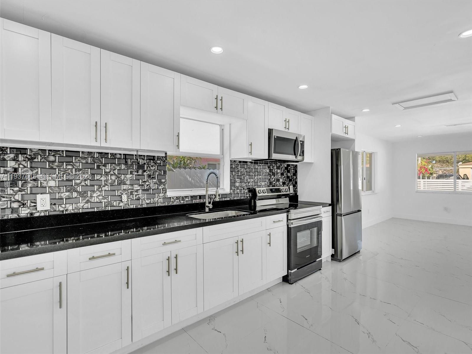 3354 Northwest 50th Street, Unit 3354 Miami, FL 33142 - Photo 10 of 26 a kitchen with granite countertop white cabinets and stainless steel appliances