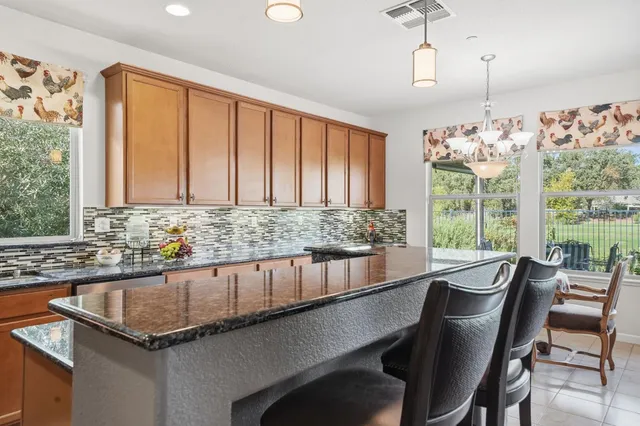a kitchen with granite countertop a stove microwave and refrigerator