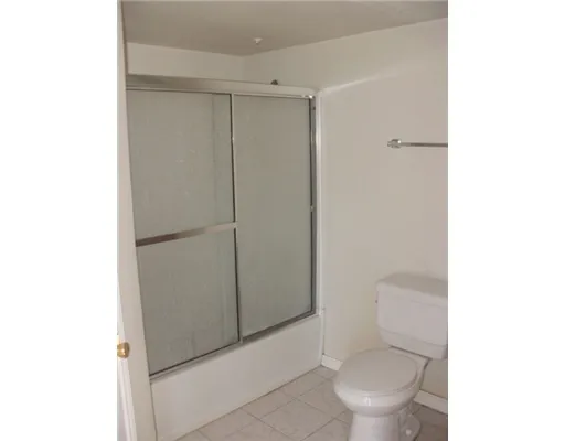 a white toilet sitting next to a shower