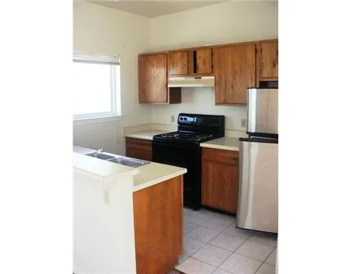 a kitchen with a stove a sink and white cabinets
