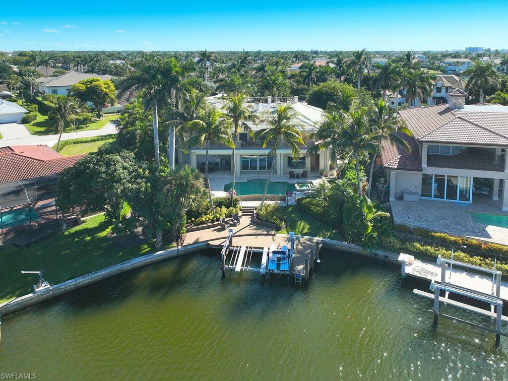377 Pirates Bight Naples, FL 34103 - Photo 40 of 44 an aerial view of a house with swimming pool patio and lake view