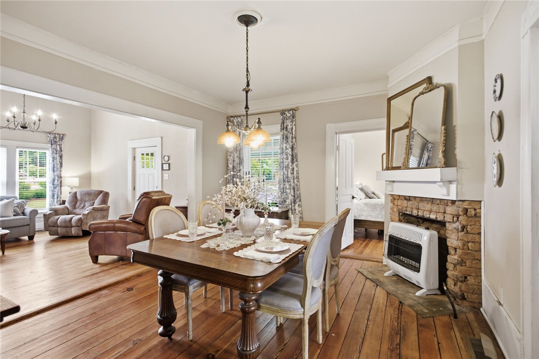 314 South Fairplay Street Seneca, SC 29678 - Photo 18 of 50 This inviting dining area features warm wood flooring, an elegant chandelier, and a charming brick fireplace.