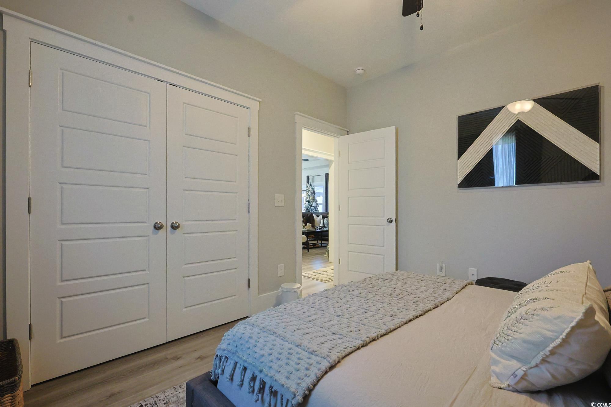 669 Pacific Commons Drive Surfside Beach, SC 29575 - Photo 21 of 36 Bedroom with a closet, light wood-type flooring, and a ceiling fan