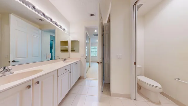 a bathroom with a double vanity sink mirror and toilet