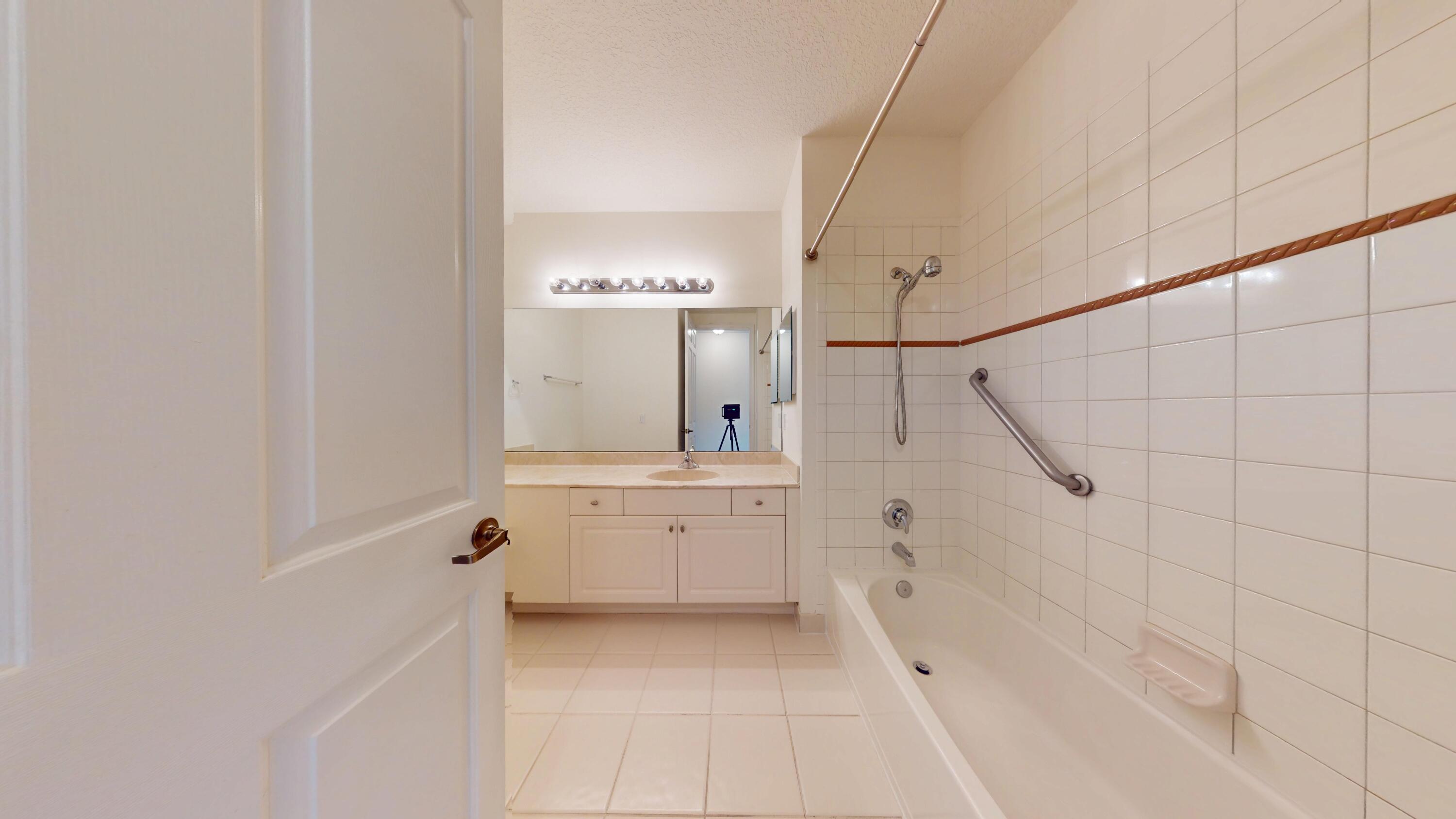 235 Chrystie Circle Delray Beach, FL 33484 - Photo 23 of 27 a bathroom with a granite countertop sink mirror and a bathtub