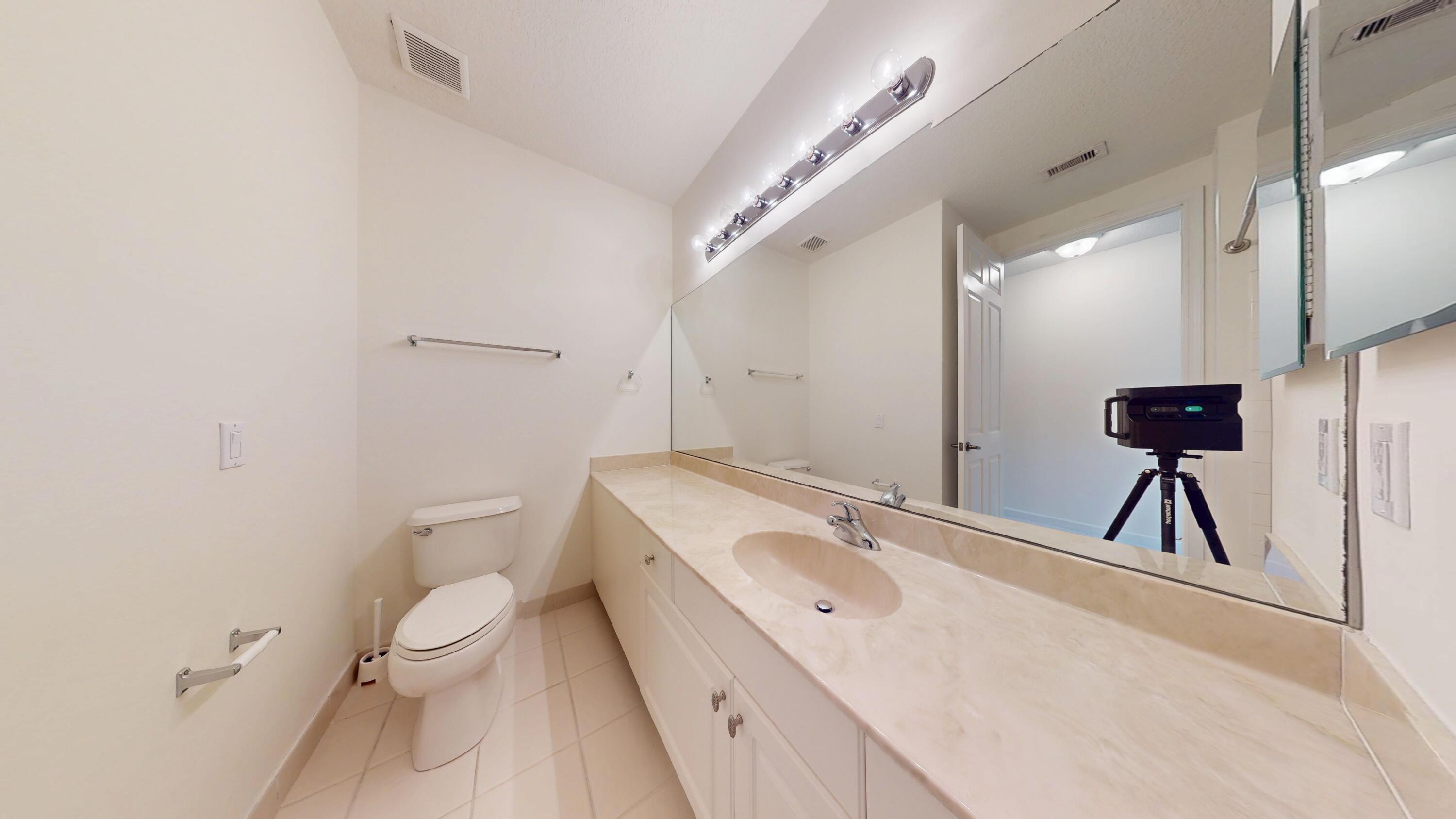 235 Chrystie Circle Delray Beach, FL 33484 - Photo 24 of 27 a bathroom with a sink a toilet and a large mirror