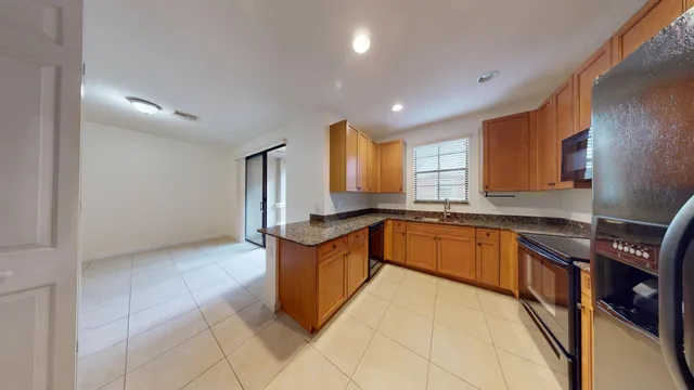 a large kitchen with granite countertop a sink and cabinets