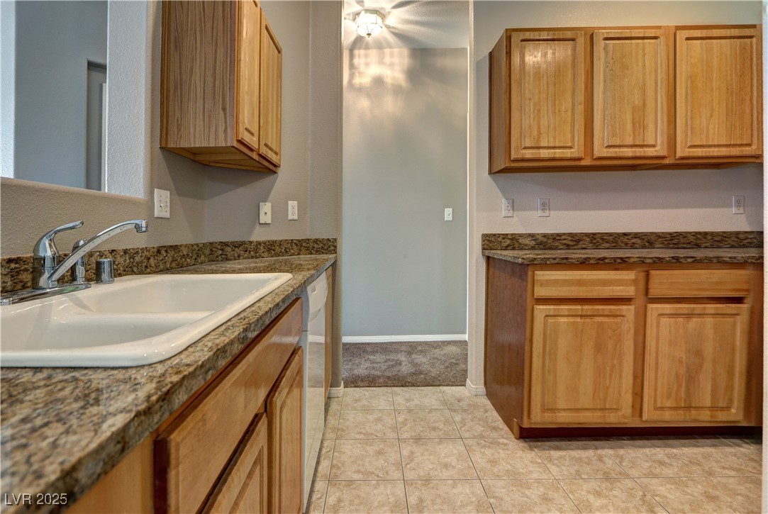 3555 Meridale Drive, Unit 2153 Las Vegas, NV 89147 - Photo 11 of 24 Kitchen featuring light tile patterned floors, white dishwasher, and brown cabinets
