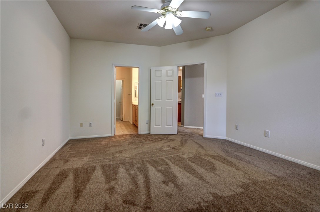 3555 Meridale Drive, Unit 2153 Las Vegas, NV 89147 - Photo 13 of 24 Unfurnished bedroom with light colored carpet, a ceiling fan, and ensuite bath