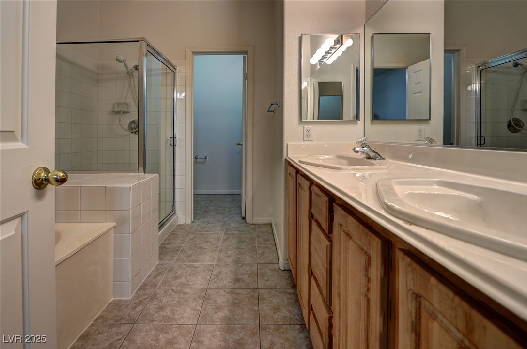 3555 Meridale Drive, Unit 2153 Las Vegas, NV 89147 - Photo 14 of 24 Bathroom with a garden tub, double vanity, light tile patterned flooring, and a shower stall