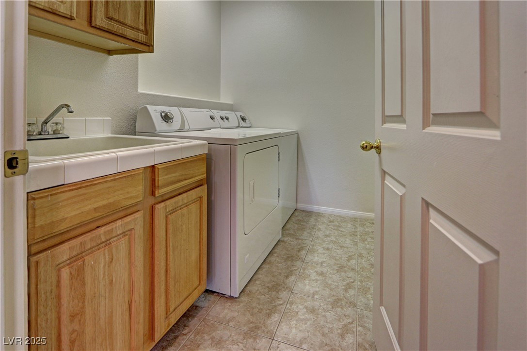 3555 Meridale Drive, Unit 2153 Las Vegas, NV 89147 - Photo 18 of 24 Washroom featuring separate washer and dryer, light tile patterned floors, and cabinet space