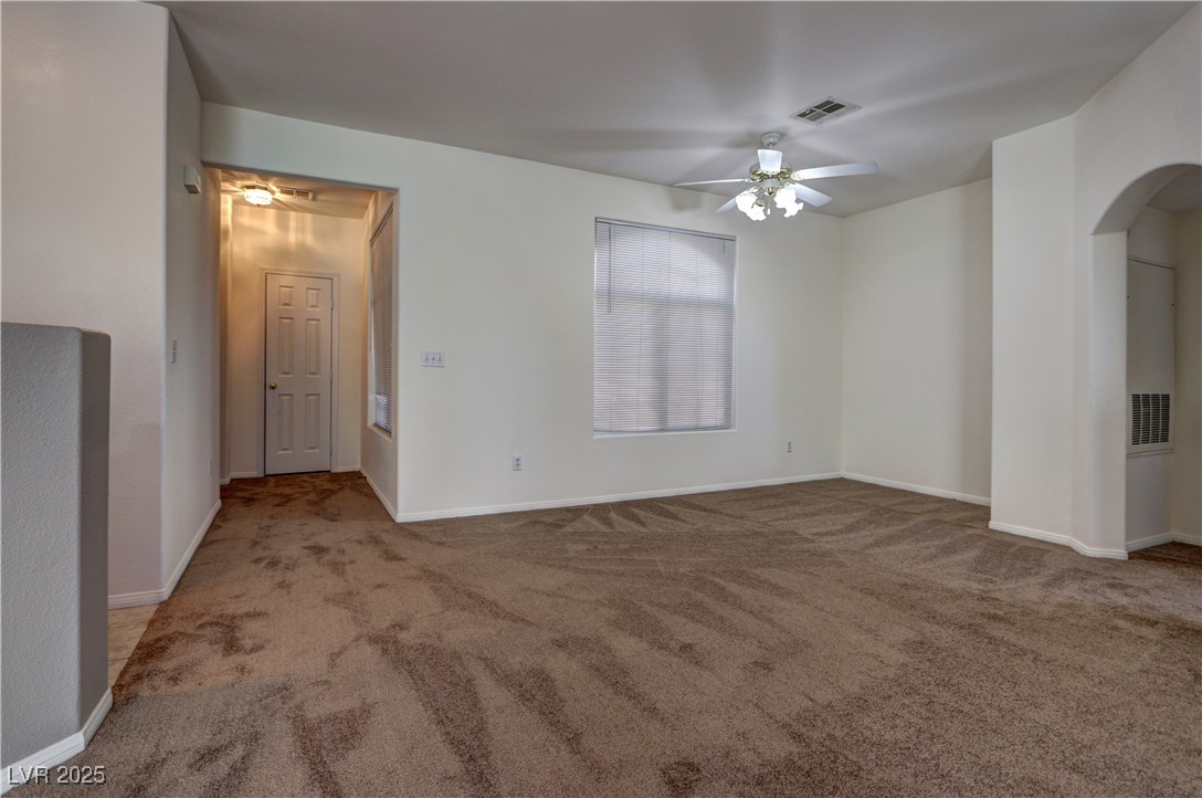 3555 Meridale Drive, Unit 2153 Las Vegas, NV 89147 - Photo 8 of 24 Spare room featuring a ceiling fan, light carpet, and arched walkways
