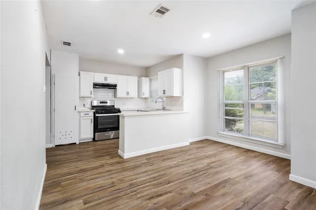 a kitchen with wooden floors and white appliances