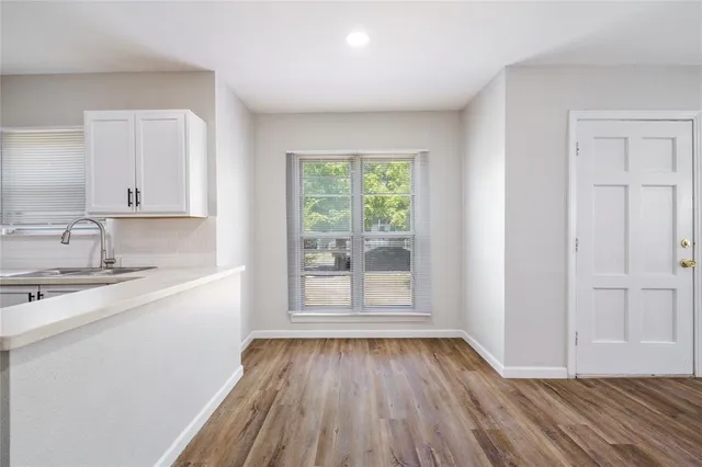 a view of a kitchen with wooden floor and a sink