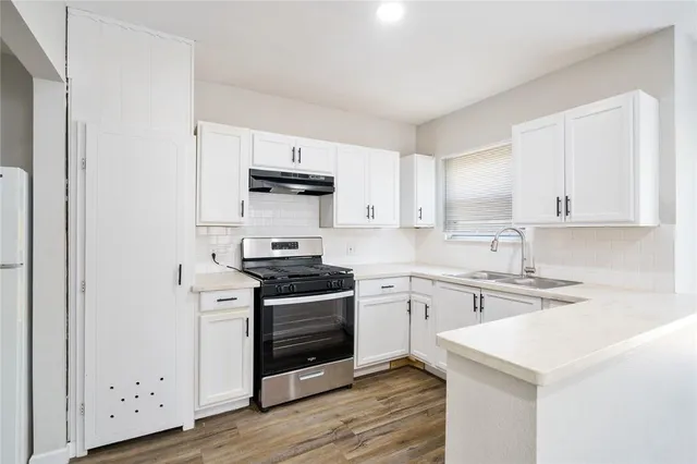 a kitchen with stainless steel appliances granite countertop a stove and a sink