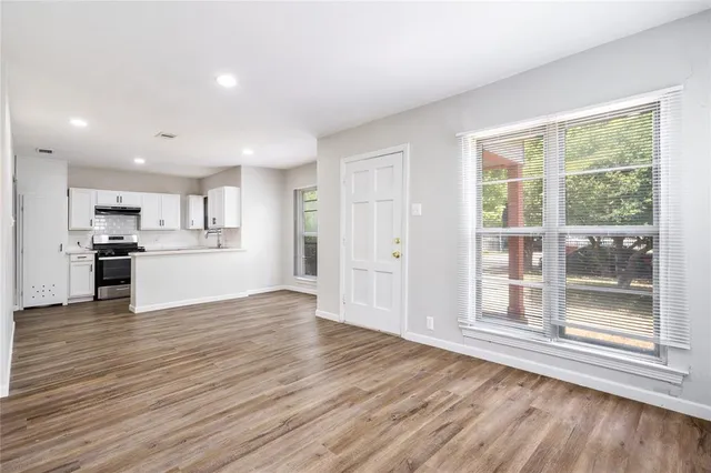 a view of a kitchen with wooden floor and a window