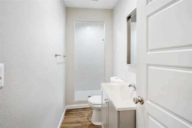 a white toilet sitting next to a bathroom sink and vanity