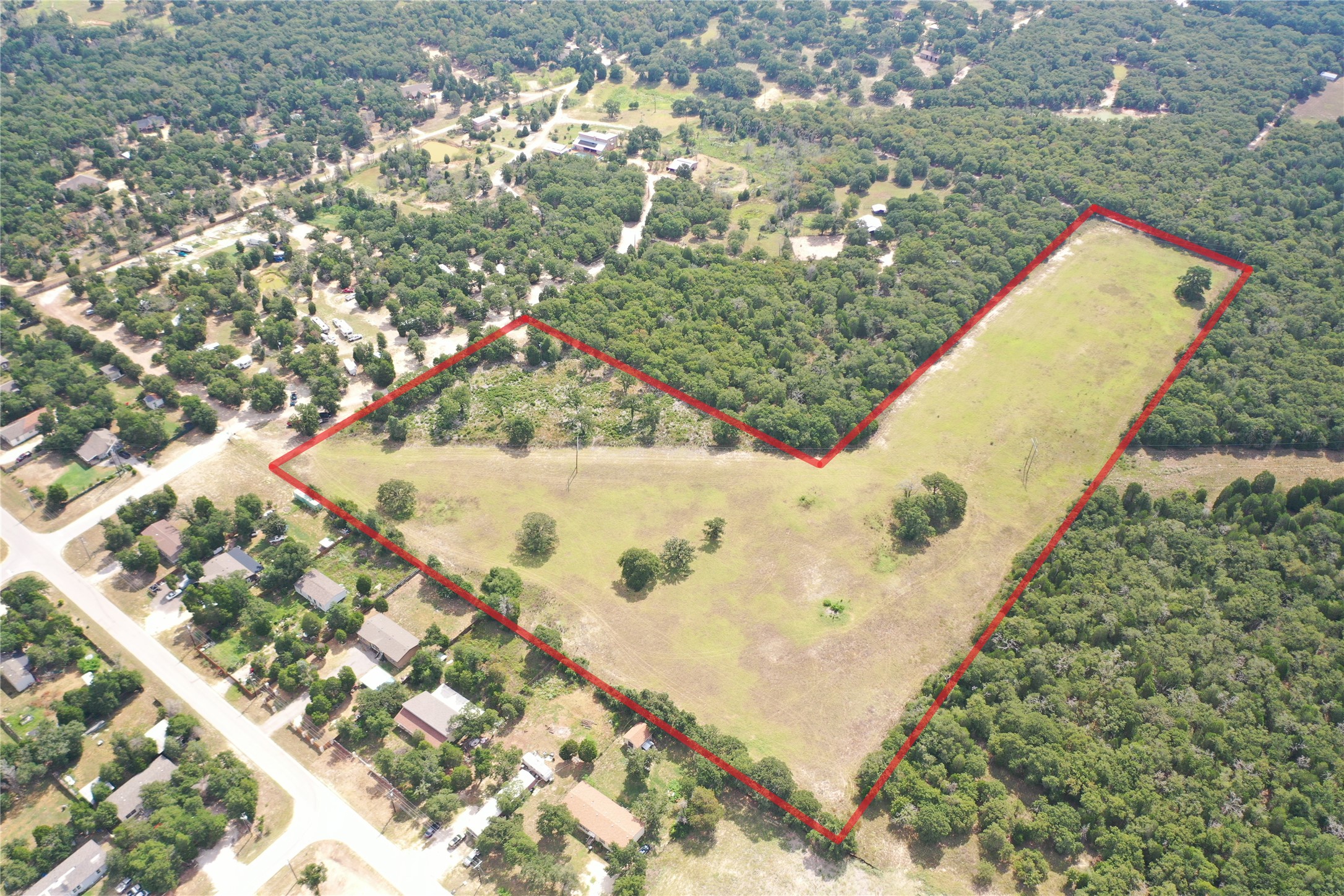 446 Las Lomas Drive Elgin, TX 78621 - Photo 4 of 9 Aerial view of property and surrounding area featuring a forest and property parcel outlined