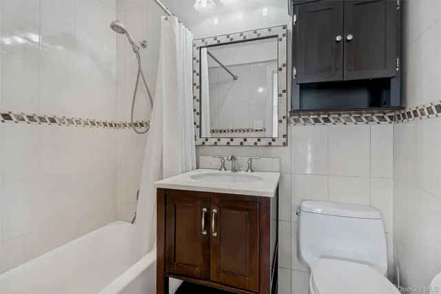 a bathroom with a granite countertop sink a toilet and a bathtub