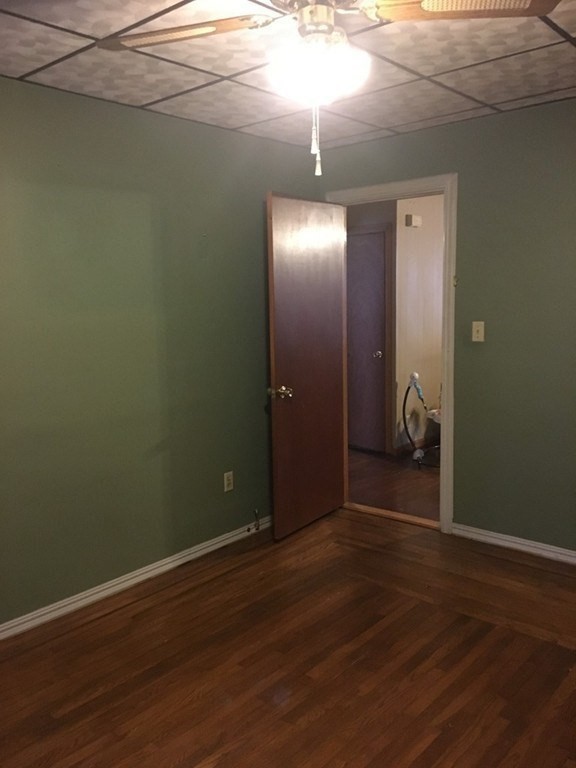 33-35 Malvey Street Fall River, MA 02720 - Photo 9 of 18 an empty room with wooden floor and windows with curtains