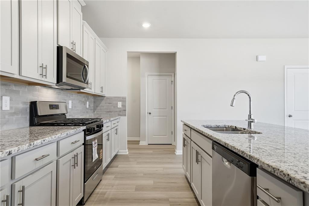 1503 Wild Fox Run Lawrenceville, GA 30045 - Photo 11 of 46 a kitchen with stainless steel appliances granite countertop a sink stove and microwave